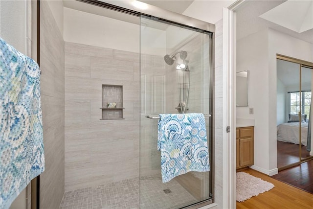 bathroom with hardwood / wood-style floors and an enclosed shower