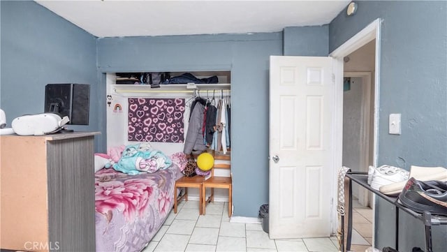 tiled bedroom with a closet