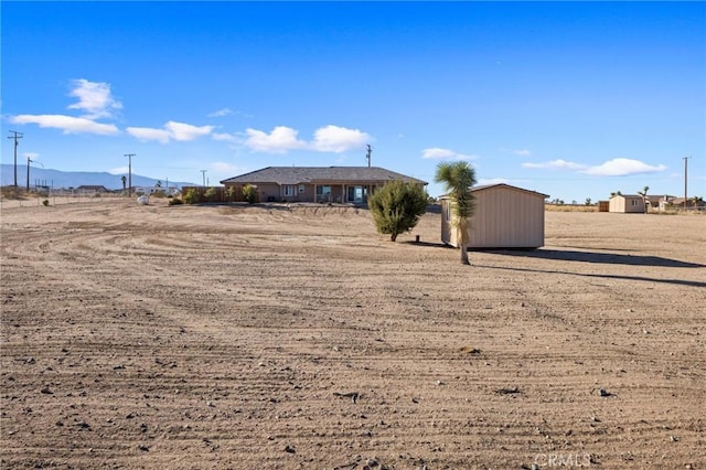 view of yard featuring a rural view and a storage unit