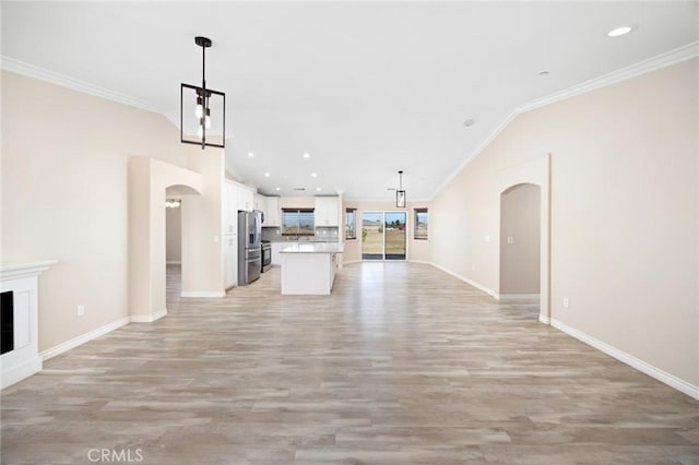 unfurnished living room with light hardwood / wood-style flooring, ornamental molding, and vaulted ceiling