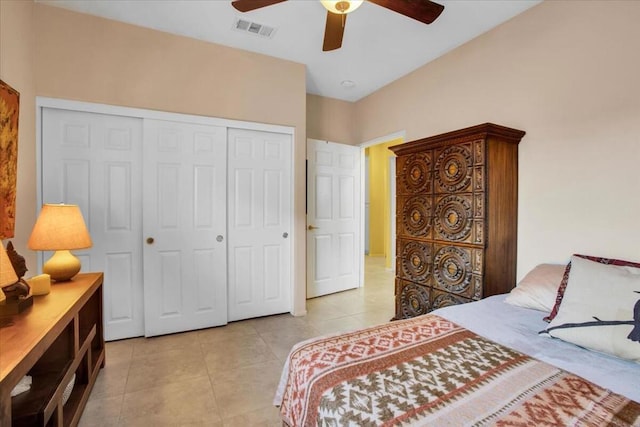 bedroom with ceiling fan, light tile patterned floors, and a closet