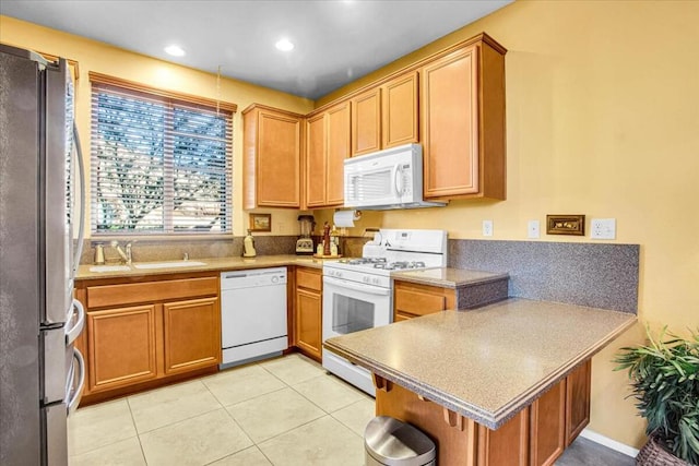 kitchen with light tile patterned flooring, sink, and white appliances