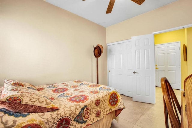 bedroom with ceiling fan, light tile patterned floors, and a closet