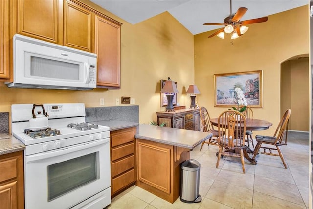 kitchen featuring ceiling fan, white appliances, kitchen peninsula, and light tile patterned flooring