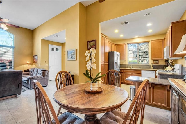 dining space featuring ceiling fan, light tile patterned floors, and sink