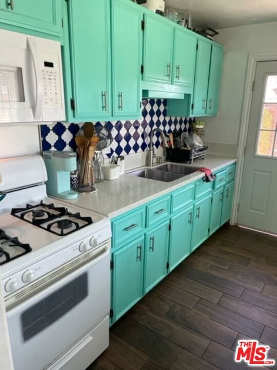 kitchen featuring sink, white appliances, and green cabinets