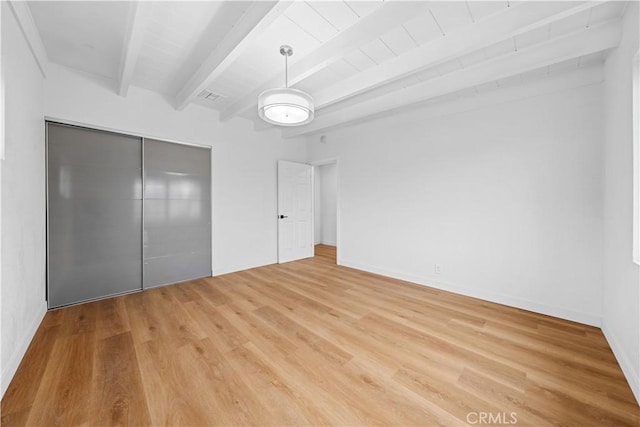 unfurnished bedroom featuring a closet, beam ceiling, wood ceiling, and light wood-type flooring