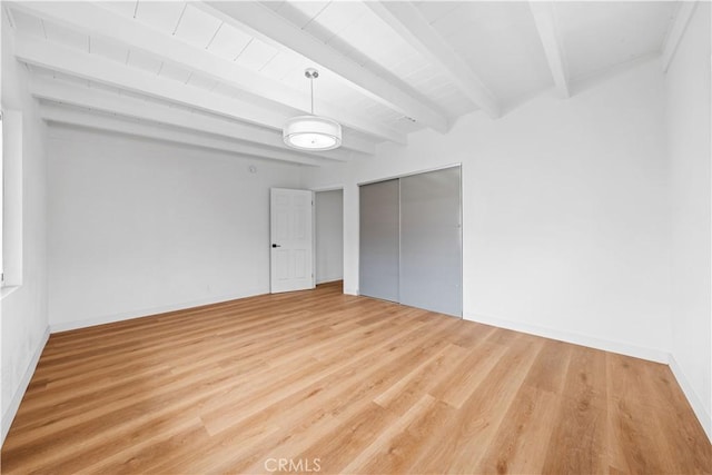 unfurnished bedroom with a closet, beam ceiling, and light hardwood / wood-style flooring