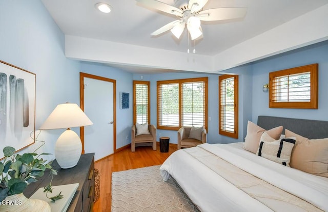 bedroom with ceiling fan, light hardwood / wood-style floors, and multiple windows