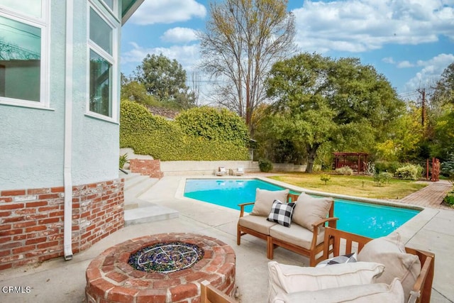 view of pool featuring a patio area, a yard, and a fire pit