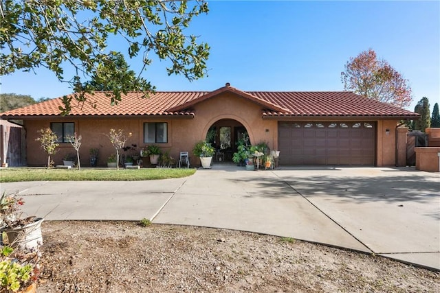 mediterranean / spanish-style home with a garage