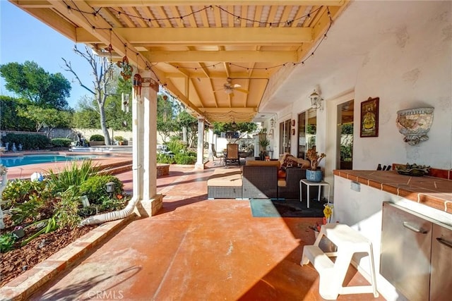 view of patio featuring ceiling fan and exterior bar