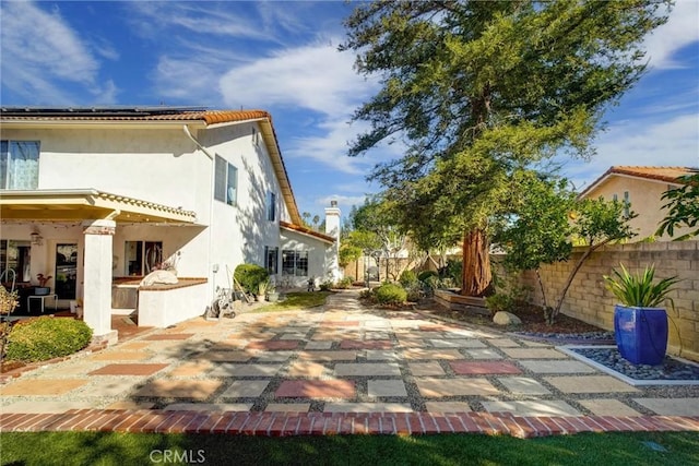 view of side of home featuring a patio area and solar panels