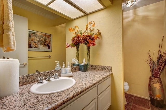 bathroom featuring toilet, crown molding, and vanity