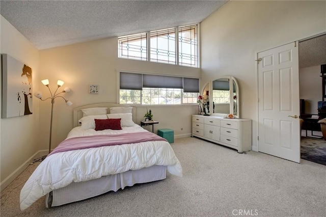 bedroom featuring high vaulted ceiling, light colored carpet, and a textured ceiling