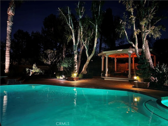 pool at twilight with a gazebo