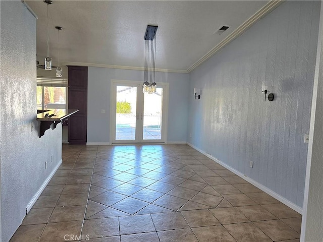 unfurnished dining area featuring tile patterned flooring, ornamental molding, and french doors