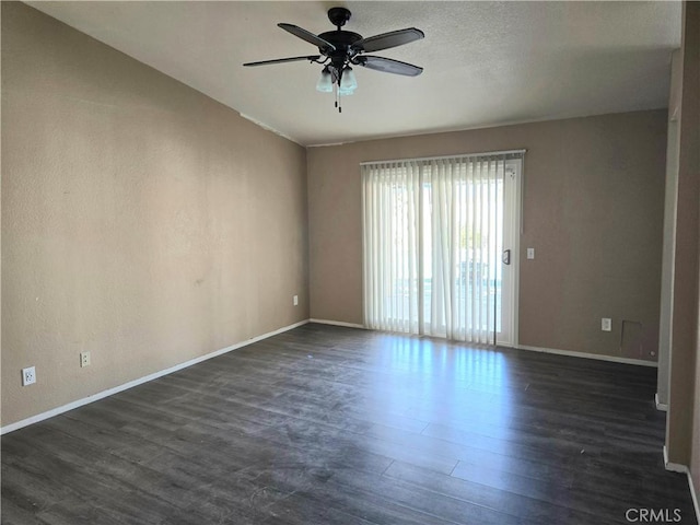 spare room with dark hardwood / wood-style flooring and ceiling fan