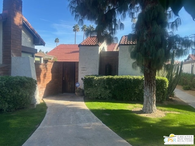 view of gate with a lawn