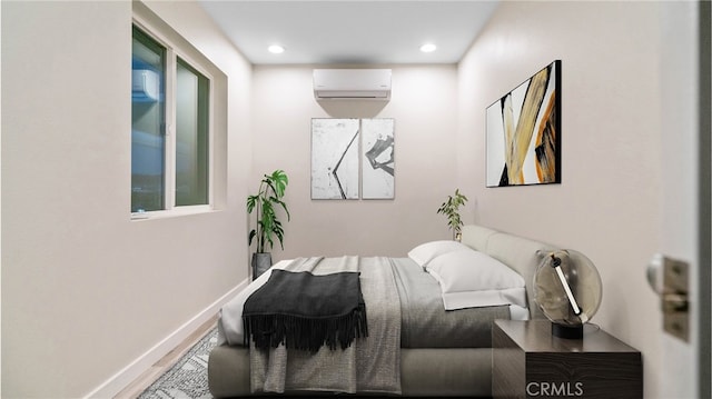 bedroom with hardwood / wood-style flooring and a wall unit AC