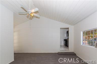 7716 Owensmouth Ave, Canoga Park, CA 91304 - carpeted empty room featuring vaulted ceiling, ceiling fan, and baseboards