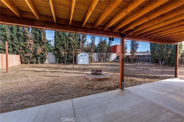 exterior space featuring an outdoor fire pit, a shed, and a patio