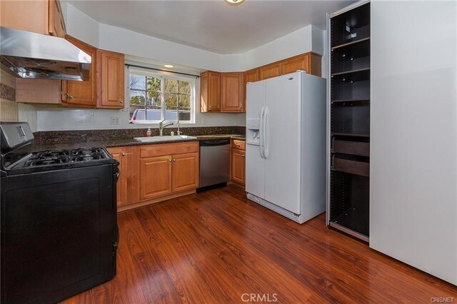 7716 Owensmouth Ave, Canoga Park, CA 91304 - kitchen featuring stainless steel appliances, a sink, under cabinet range hood, dark countertops, and dark wood-style floors