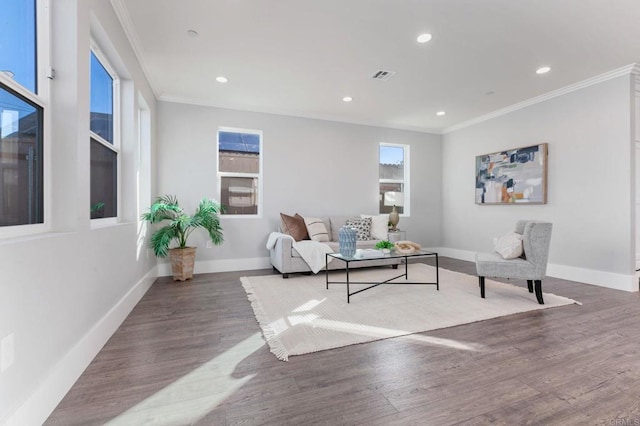 living room with visible vents, crown molding, baseboards, and wood finished floors