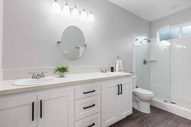 bathroom with a sink, wood finished floors, and a shower stall