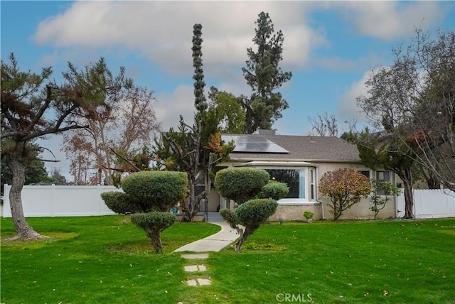 exterior space featuring a front lawn and solar panels