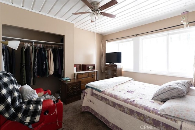 carpeted bedroom with a ceiling fan and a closet