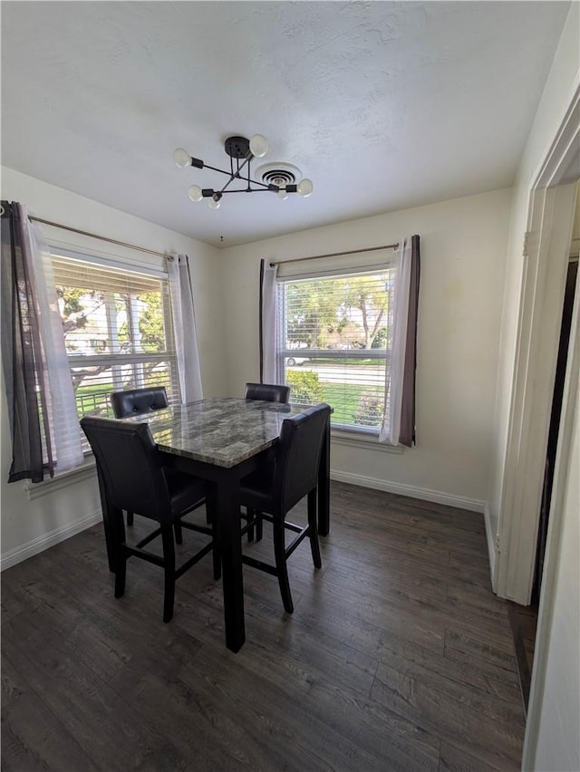 dining room featuring plenty of natural light, dark wood-style floors, and a chandelier