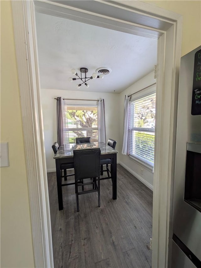 dining room featuring dark wood-style floors, visible vents, an inviting chandelier, and plenty of natural light