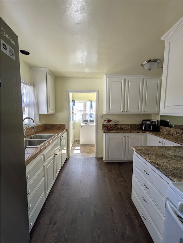 kitchen featuring a healthy amount of sunlight, white cabinetry, a sink, and dark wood-type flooring