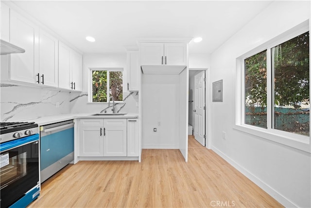 kitchen with sink, white cabinets, stainless steel dishwasher, and range