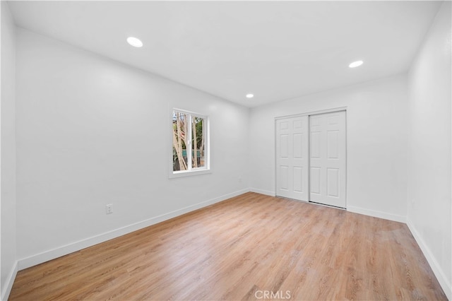 unfurnished bedroom featuring a closet and light hardwood / wood-style flooring