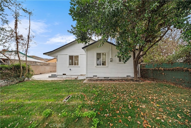 back of house featuring a lawn