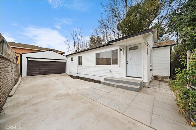 view of front of property featuring a garage and an outdoor structure