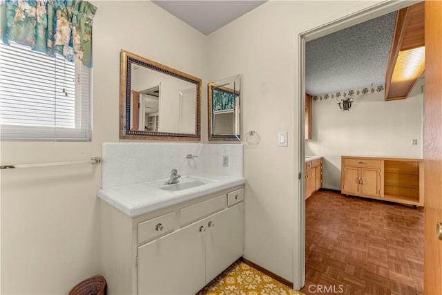 bathroom with parquet floors, backsplash, and vanity