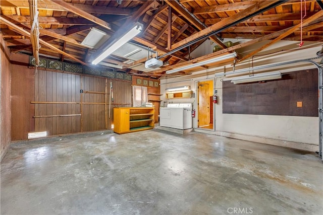 garage featuring a garage door opener, washing machine and clothes dryer, and wooden ceiling