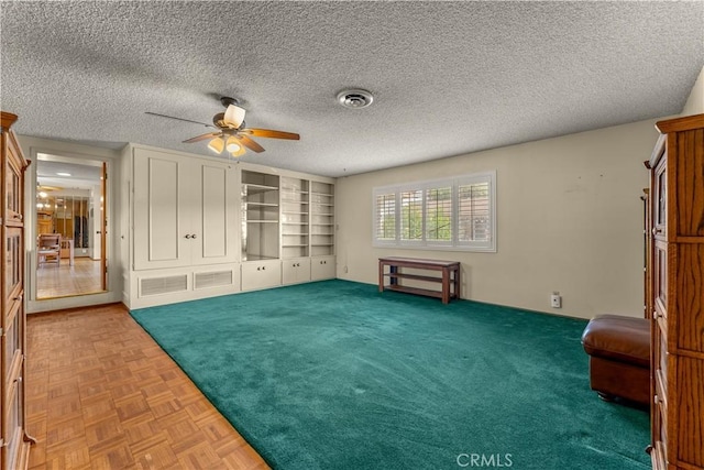 interior space with ceiling fan and a textured ceiling