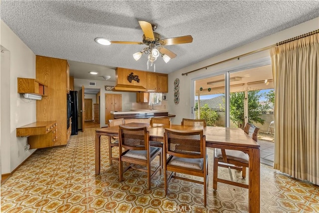 dining room featuring ceiling fan and a textured ceiling