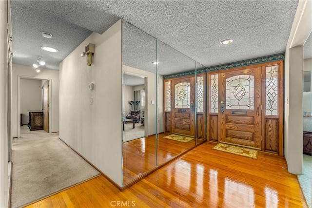 entrance foyer featuring a textured ceiling and light hardwood / wood-style floors