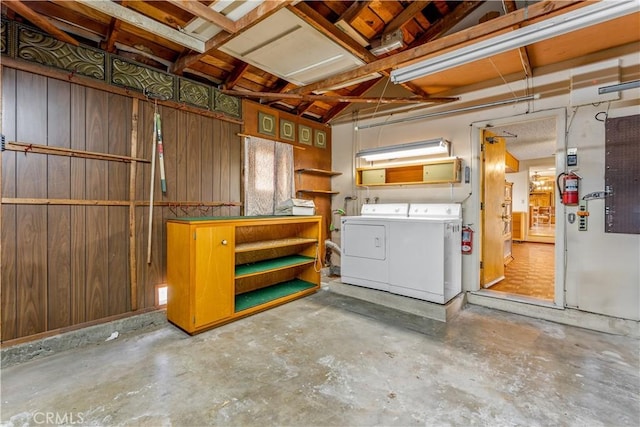 basement featuring separate washer and dryer and wood walls