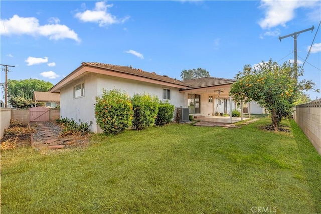 back of house featuring a patio, a lawn, and central AC