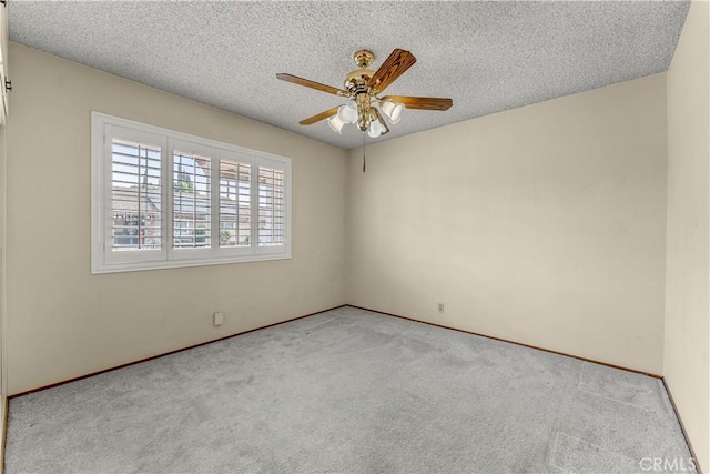 spare room featuring ceiling fan, light colored carpet, and a textured ceiling