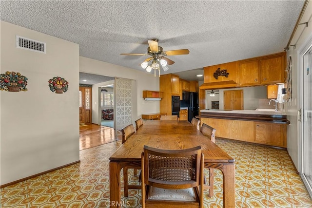 dining space featuring a textured ceiling and ceiling fan