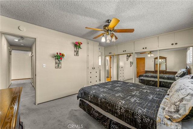 carpeted bedroom featuring ceiling fan and a textured ceiling