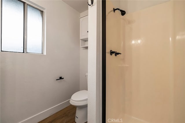 bathroom featuring toilet, hardwood / wood-style flooring, and walk in shower