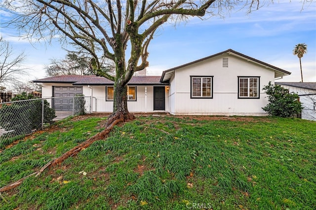 ranch-style house featuring a garage and a front lawn